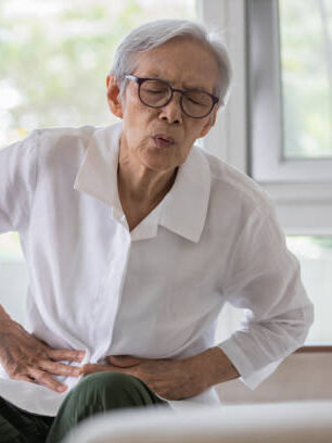 photo of large intestine is on the senior woman body against gray background, People With Stomach ache problem concept, Female anatomy