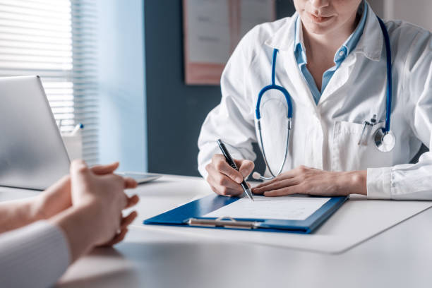 Image of an antimicrobial sitting on a table. Doctor sitting at desk and writing a prescription for her patient