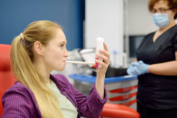Image of a dietitian holding a stack of papers in hand which are test results. A nurse in the laboratory offers the patient a medical machine for blowing to perform a test for Helicobacter. Modern technology for diagnosis of helicobacter pylori bacterial infection.