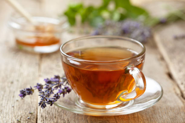 lavender tea in a glass cup, honey, lavender flowers on the old wooden background.