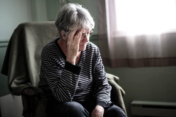 Image of a dietitian holding a stack of papers in hand which are test results. Old woman stressed about her gut issues.