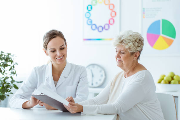 Image of an antimicrobial sitting on a table. Smiling nutritionist showing personalised weight-loss diet plan to the patient