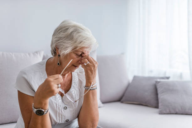 Image of an antimicrobial sitting on a table. Elderly woman suffering from headache at home. Close up aged woman with headache. Health care, pain, stress, age and people concept