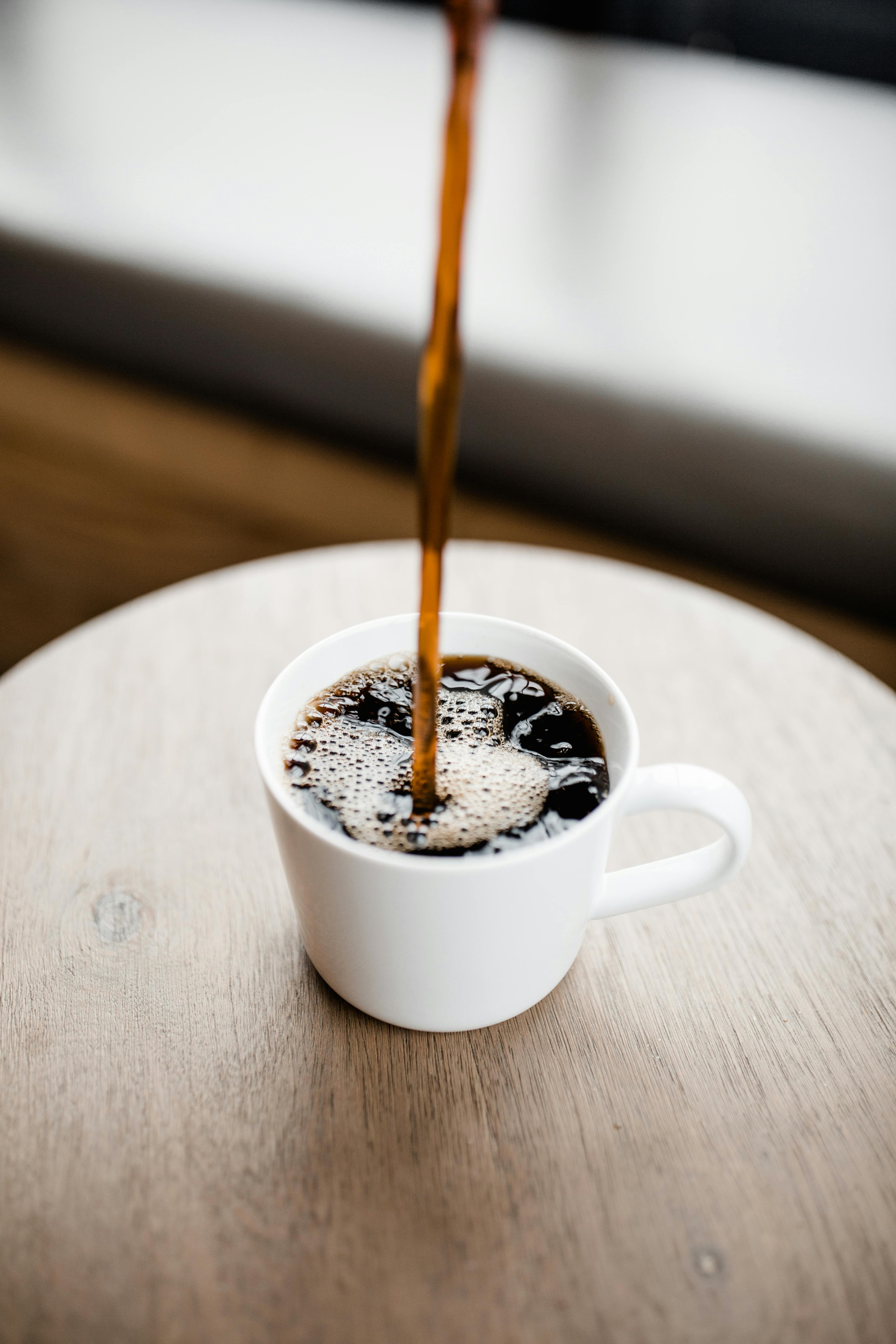 Image of a dietitian holding a stack of papers in hand which are test results. Cup on coffee.
