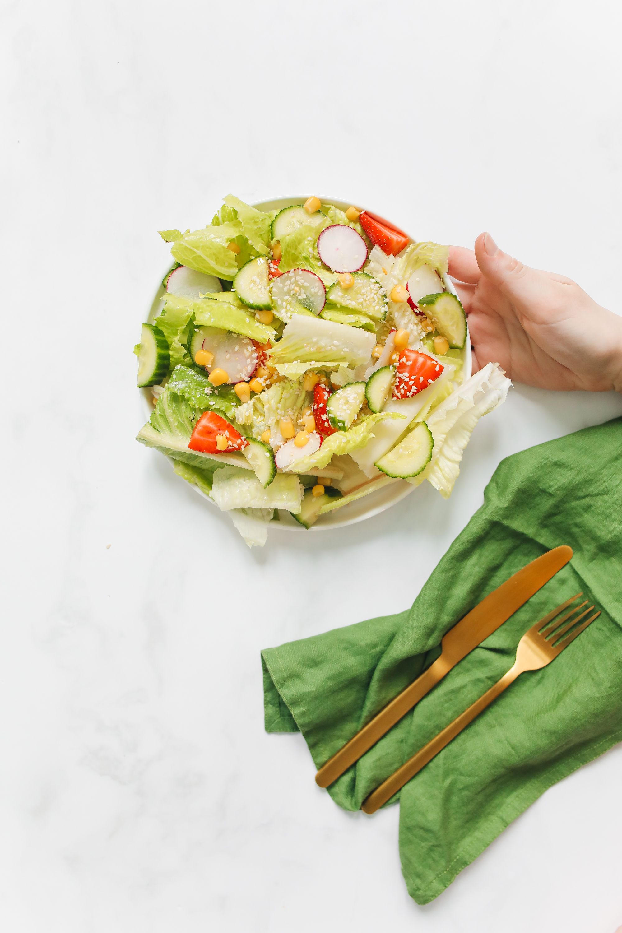 Image of a dietitian holding a stack of papers in hand which are test results. raw salad that can cause bloating