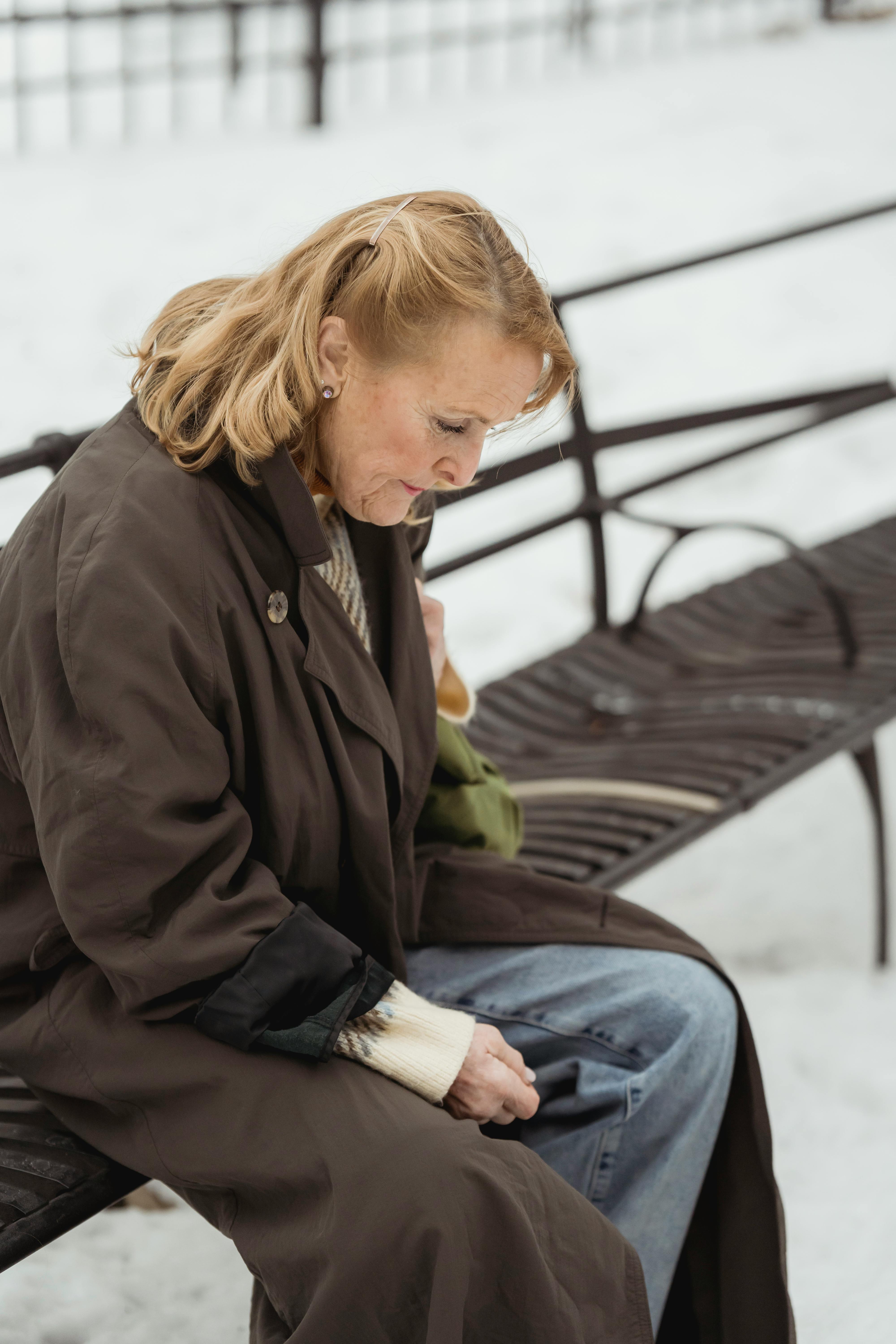 Old woman judging herself on a bench.